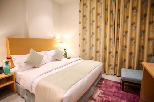 a hotel room with a bed and a chair at Tanuma Aram Hospitality - Hotel Apartments in Tanomah