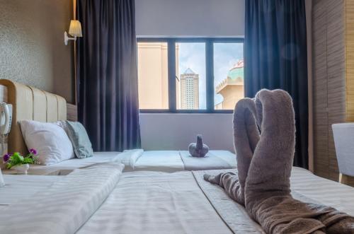 a person with their feet up on a bed at GM Grand Moments Bandar Sunway in Petaling Jaya