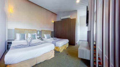 a hotel room with two beds and a television at GM Grand Moments Bandar Sunway in Petaling Jaya