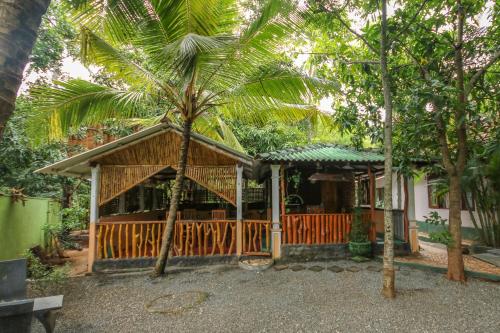 une maison avec un palmier en face dans l'établissement Green Park Safari House, à Uda Walawe