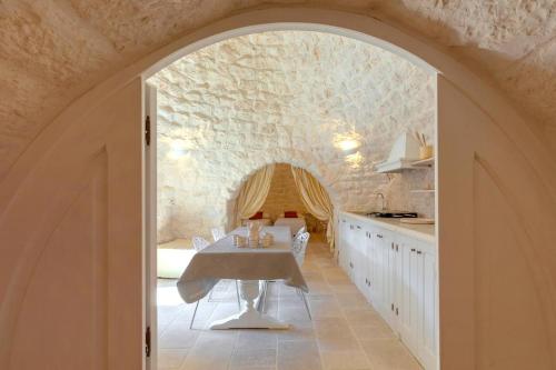 uma arcada numa cozinha com uma mesa e um balcão em Trullo Dell'aia em Monopoli