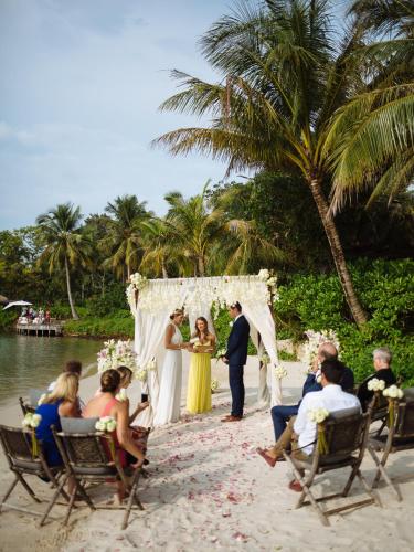 a bride and groom standing under a wedding arch on the beach at Song Saa Private Island in Song Saa Private Island