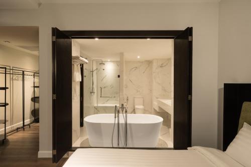 a large bathroom with a tub and a shower at S Ram Leisure Hotel SHA PLUS in Bangkok