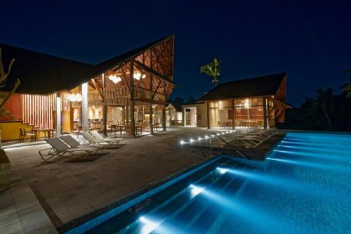 a villa with a swimming pool at night at Tejaprana Bisma - CHSE Certified in Ubud