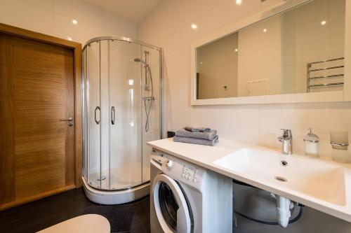 a bathroom with a washing machine and a sink at Liepaja Apartments in Liepāja