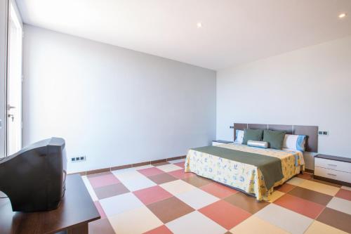 a bedroom with a bed and a checkered floor at MOSAIC in Sa Ràpita
