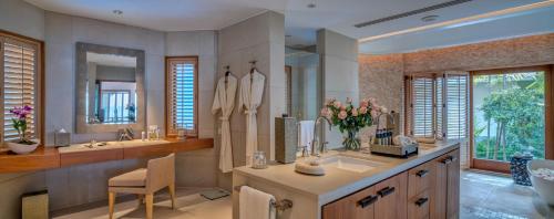 łazienka z 2 umywalkami i dużym lustrem w obiekcie Villa Macaque and Villa Languor w mieście Railay Beach