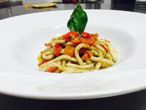 a white plate of pasta with vegetables on it at Bio Agriturismo Il Melograno di Banditella Ristorante in Alberese