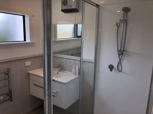 ein Bad mit einem Waschbecken und einem Spiegel in der Unterkunft Granny Stringer’s Cottage in Roxburgh