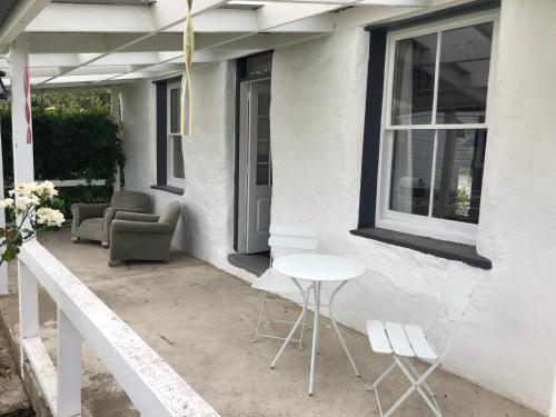 a patio with chairs and a table and a window at Granny Stringer’s Cottage in Roxburgh