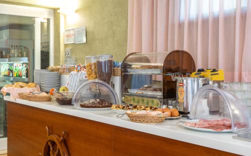 a buffet with food on a counter in a restaurant at Hotel Corallo in Fano