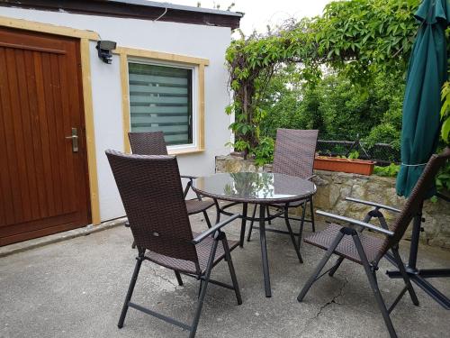 einen Terrassentisch mit Stühlen, einem Tisch und einem Sonnenschirm in der Unterkunft Ferienhaus Am Graseberg in Neinstedt