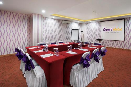 a conference room with red and white tables with purple bows at Quest San Denpasar by ASTON in Denpasar