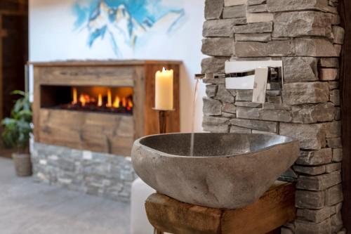 a bathroom with a stone sink and a fireplace at Hotel Antika in Zermatt