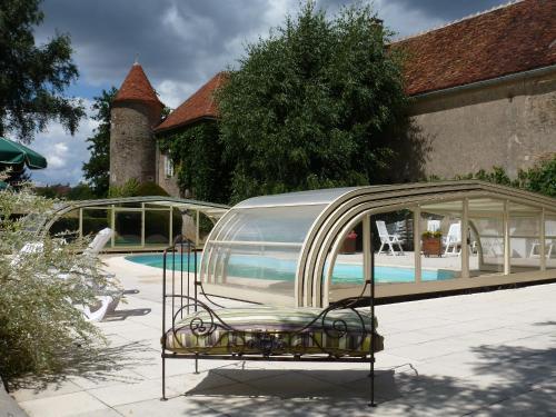 une maison en verre installée à côté d'une piscine dans l'établissement Château de Ribourdin, à Chevannes