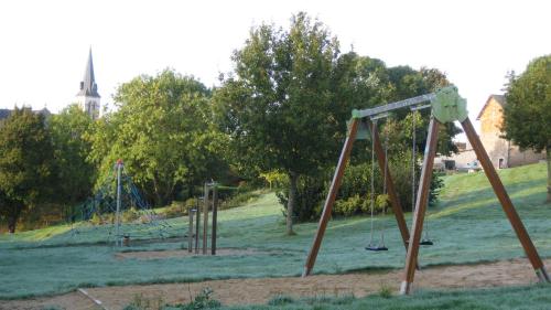 un patio de juegos vacío con columpios en un parque en Logement Vendée, en Saligny