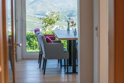 a dining room table with chairs and a table and a window at Gästehaus-Weingut Loersch in Leiwen