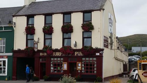 a man standing in front of a building at Murphy's Pub and Bed & Breakfast in Dingle