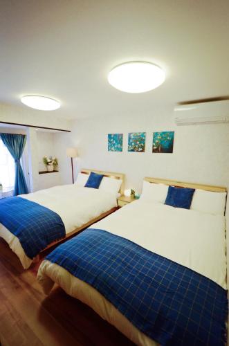 two beds sitting next to each other in a bedroom at Yamato Family House - 2 Floors | 3 bedrooms in Osaka