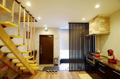 a kitchen with a wooden staircase and a room at Yamato Family House - 2 Floors | 3 bedrooms in Osaka