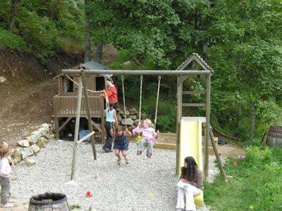 a group of children playing on a swing set at La Bergerie du Plateau in Cros-de-Géorand