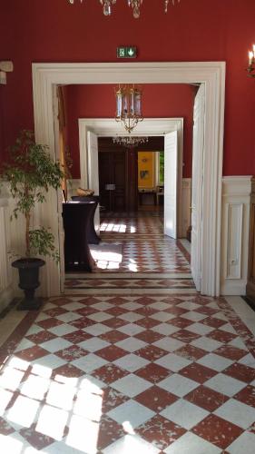 a room with red walls and a checkered floor at Chateau-Hotel De Belmesnil in Saint-Denis-le-Thiboult