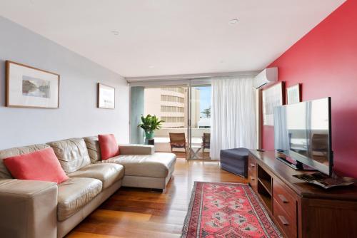 a living room with a couch and a flat screen tv at manlybeachonline.com713 At The Beach in Sydney