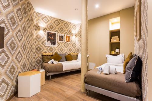 a bedroom with two beds and a wall with patterns at CMG Nation/ Vincennes in Paris