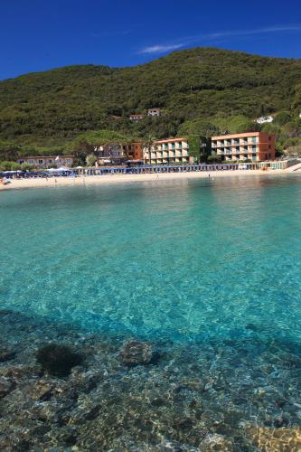 a view of a beach with buildings and the water at Hotel Desiree in Procchio