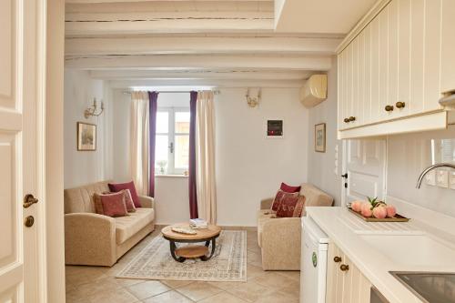 una cucina e un soggiorno con divano e tavolo di Old Town Luxury Suites 'Lady' a Città di Corfù