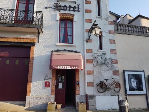 a building with a hotel sign on the side of it at Logis Hotel La Tourelle du Beffroi in Bourbon-Lancy