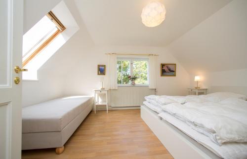 a white bedroom with a bed and a window at Snowwhites House in Borre