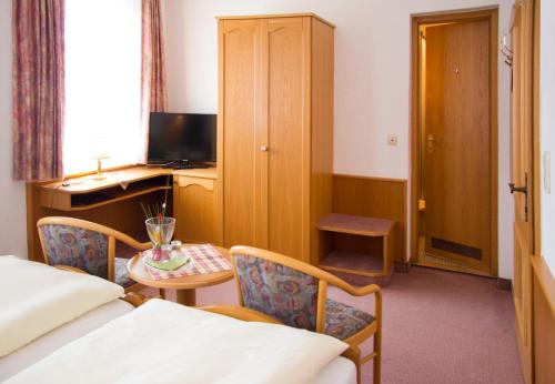 a hotel room with a bed and a table and a desk at Gasthof und Pension zur Sonne in Schollbrunn