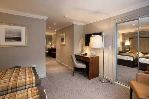 a hotel room with a bed desk and a bedroom at Cruachan Hotel in Fort William