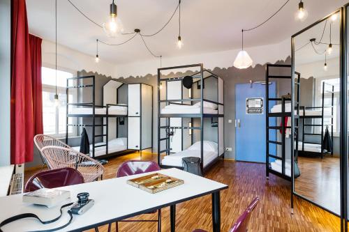 a room with a table and chairs and bunk beds at The Circus Hostel in Berlin