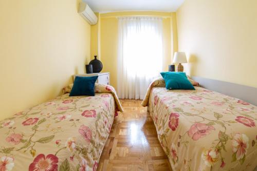 two beds sitting next to each other in a room at Apartamentos Duque Martinez Izquierdo. in Madrid