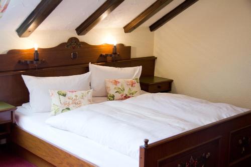 a bedroom with a bed with white sheets and pillows at Gasthof und Pension zur Sonne in Schollbrunn