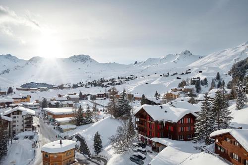a town covered in snow with mountains in the background at Hotel Sonnenhalde, Arosa in Arosa