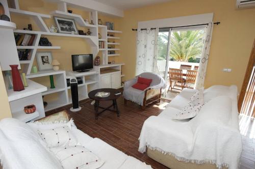 Sala de estar con 2 sofás blancos y TV en VG1C, Gran apartamento en zona del Puerto, en Villajoyosa