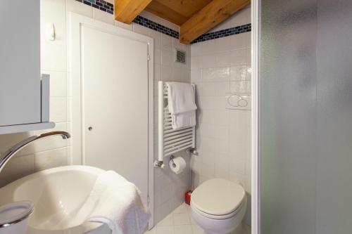 La salle de bains blanche est pourvue de toilettes et d'un lavabo. dans l'établissement Stella Marina 3, à Venise