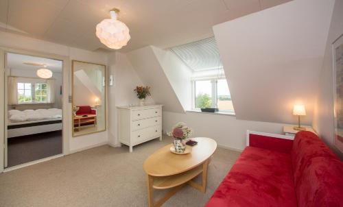 Una sala de estar con un sofá rojo y una mesa. en Søndergård, en Borre