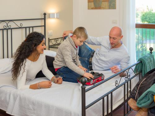 een groep mensen op een bed met een kind bij Residence Eden in Peschiera del Garda