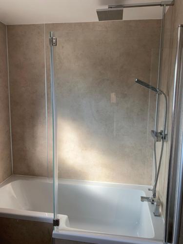 a shower in a bathroom with a bath tub at Newly Renovated & Spacious House in Seahouses