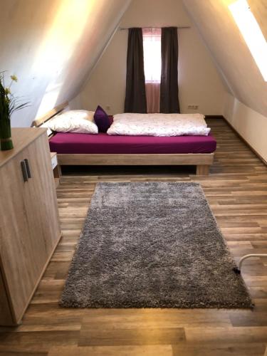 a room with a bed and a rug on the floor at Ferienhaus Oliveira in Spalt