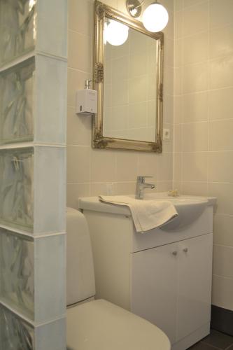 La salle de bains est pourvue d'un lavabo, d'un miroir et de toilettes. dans l'établissement Hotell Wettern, à Karlsborg
