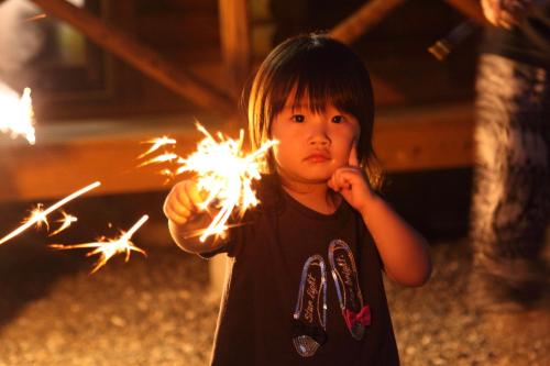 a little girl holding a sparkler in her hand at 美濃田の淵キャンプ村 in Higashimiyoshi