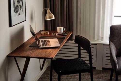 a desk with a laptop and a chair in a room at Comwell Borupgaard in Snekkersten