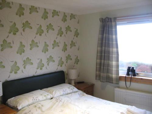 a bedroom with a bed with a green and white wall at The Anchorage in Ose
