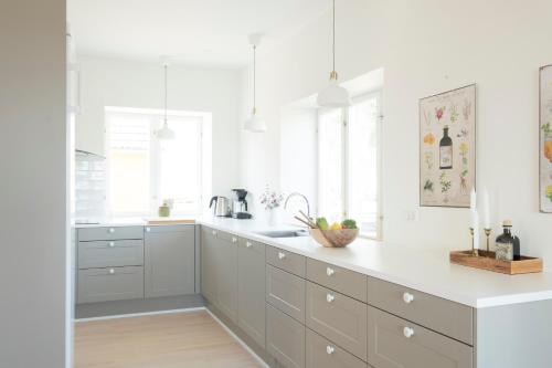 a kitchen with white cabinets and white counters at The Light House in Borre