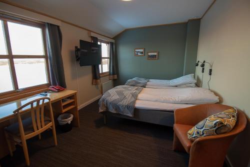 a bedroom with a bed and a chair and a desk at Lakselv Hotel in Lakselv